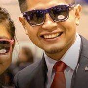 Students dressed nicely at Enactus event smiling at camera with sunglasses on