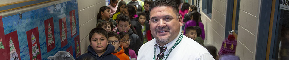 Principal in hallway with students