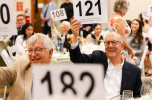 People holding up numbers during the paddle raise portion of the Bounty of the Valley Scholarship Dinner.