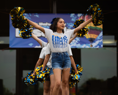 HeritageRiseUp-EW-12 A group of people holding pom poms