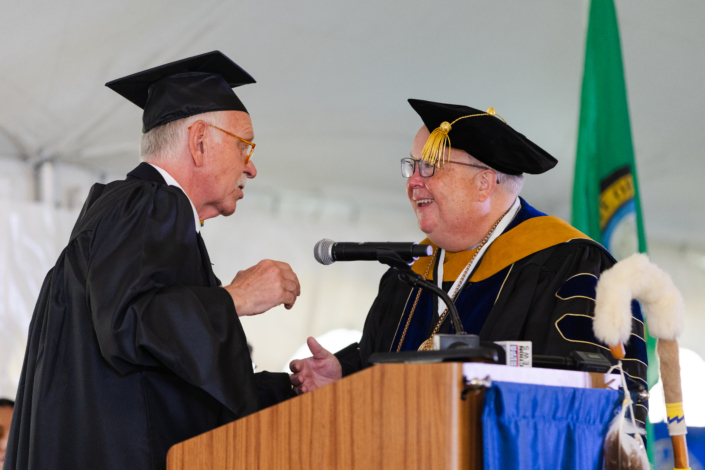 Presidential Inauguration: Installation A person in graduation gown talking to another person