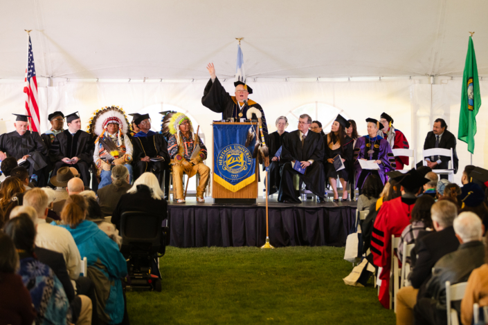 Presidential Inauguration: Installation A person in a black gown and cap speaking to a group of people