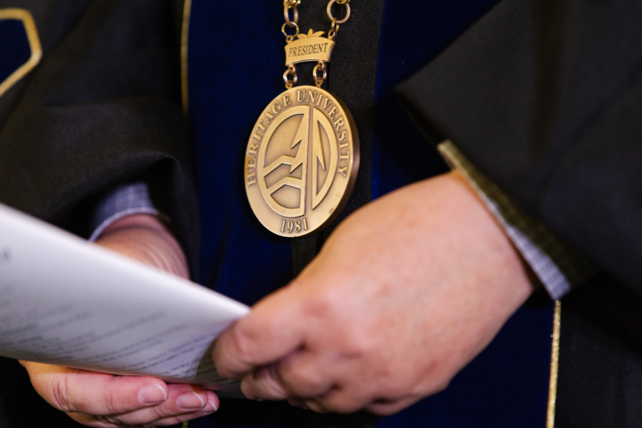 Presidential Inauguration: Installation A person wearing a medallion and holding a piece of paper