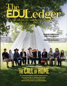A magazine cover with a group of people sitting on chairs in front of a tipi
