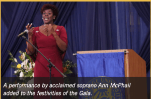 A person in a red dress standing at a microphone