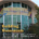 Photograph of Heritage University building featuring large glass windows and a colorful banner with university name. Text overlay highlights "Building Momentum," noting student success three years after opening in Kennewick and efforts to reach next generation of Tri-Cities scholars.